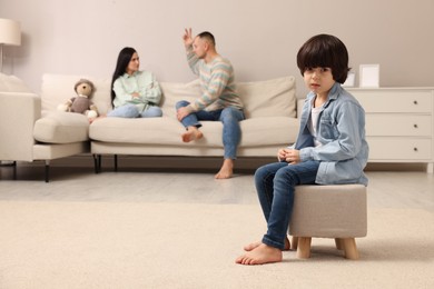Photo of Couple arguing at home, focus on their upset child