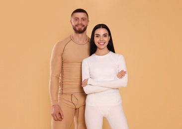 Photo of Man and woman in warm thermal underwear on beige background