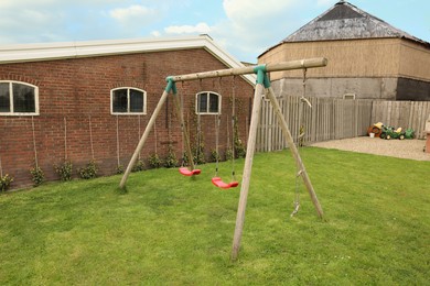 Spacious backyard with swing set on spring day