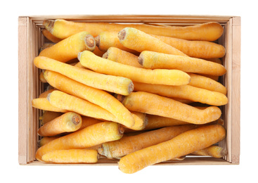 Raw yellow carrots in wooden crate isolated on white, top view