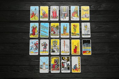 Tarot cards on black wooden table, flat lay