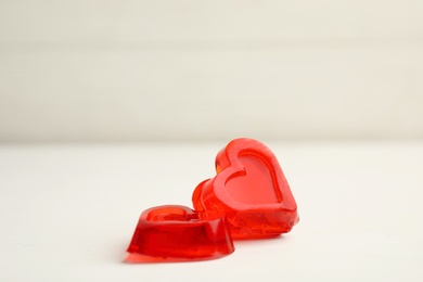 Tasty heart shaped jelly candies on white table