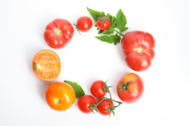 Frame of different ripe tomatoes and leaves on white background, flat lay. Space for text