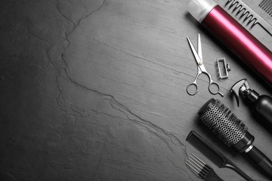 Flat lay composition of professional scissors and other hairdresser's equipment on black table, space for text. Haircut tool