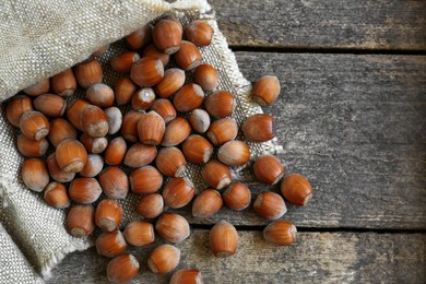 Photo of Tasty hazelnuts on wooden table, top view