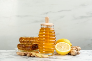 Photo of Honey, ginger and lemon on white marble table. Natural cold remedies