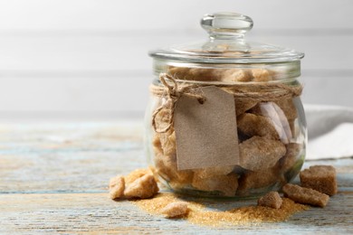 Photo of Glass jar with chunks of brown sugar on rustic table, space for text