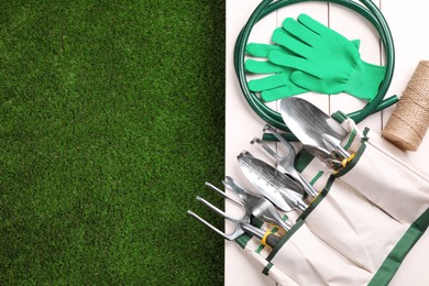 Different gardening tools on green grass, flat lay. Space for text