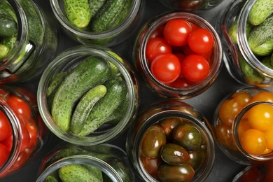 Pickling jars with fresh vegetables on table, flat lay