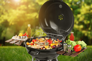 Barbecue grill with meat products and vegetables outdoors on sunny day, closeup
