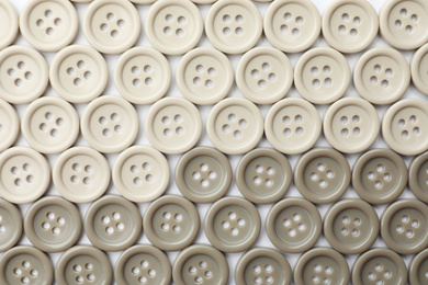 Many plastic sewing buttons on white background, top view