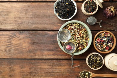 Many different herbal teas on wooden table, flat lay. Space for text