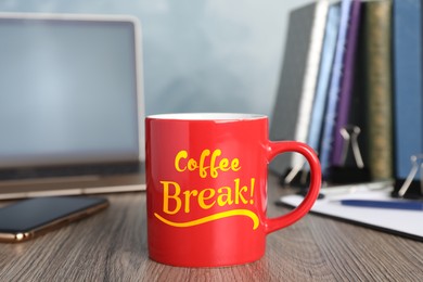 Mug with inscription Coffee Break on wooden table in office