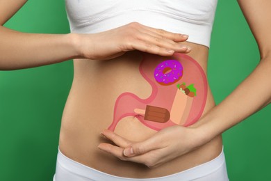Image of Woman with image of stomach full of junk food drawn on her belly against green background, closeup. Unhealthy eating habits
