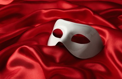 White plastic theatre mask on red fabric