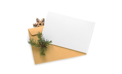 Blank greeting card, envelope and Christmas decor on white background, top view. Space for text