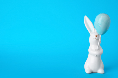 Bunny ceramic figure as Easter decor on blue background. Space for text