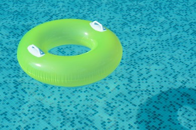 Light green inflatable ring floating in swimming pool. space for text