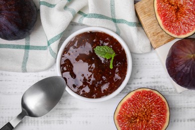 Photo of Tasty sweet fig jam and fruits on white wooden table, flat lay