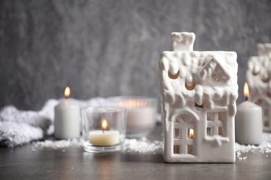 Composition with house shaped candle holders on grey stone table, space for text. Christmas decoration