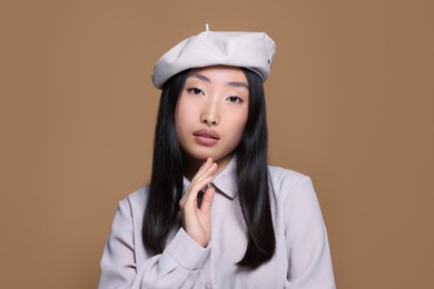 Photo of Portrait of beautiful young Asian woman in stylish outfit on beige background