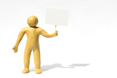 Human figure made of yellow plasticine holding blank sign on white background. Space for text