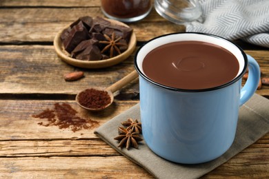 Yummy hot chocolate in mug on wooden table, space for text