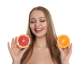 Young woman with cut orange and grapefruit on white background. Vitamin rich food