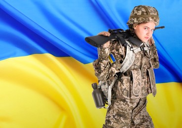 Armed soldier in military camouflage uniform and Ukrainian flag on background, space for text. Stop war