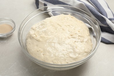 Photo of Fresh dough for cake and dry yeast on marble table