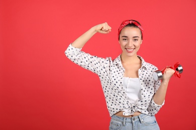 Woman with dumbbell as symbol of girl power on red background, space for text. 8 March concept
