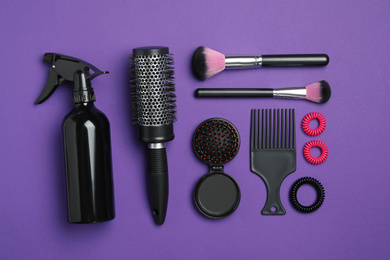 Flat lay composition with modern hair comb and brush on purple background