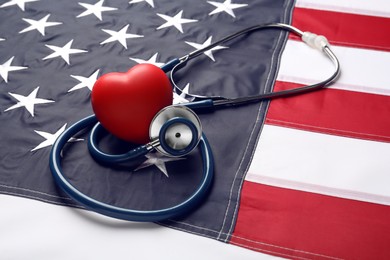 Stethoscope and red heart on American flag, closeup
