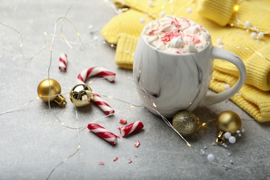 Photo of Composition with delicious marshmallow drink, festive decor and yellow sweater on light grey table