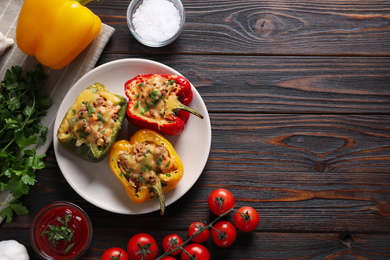 Flat lay composition with tasty stuffed bell peppers on wooden table, space for text