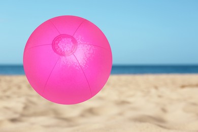 Pink inflatable beach ball and seascape on background