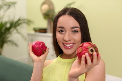 Photo of Young woman with fresh pitahayas at home. Exotic fruits