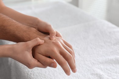 Man receiving hand massage in wellness center, closeup