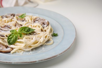 Photo of Delicious pasta with mushrooms and cheese on white table, closeup