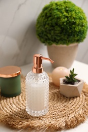Soap dispenser and plants on countertop in bathroom