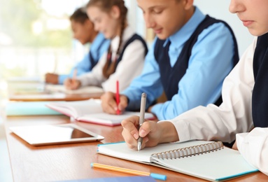 Teenage students in stylish school uniform at desk, closeup