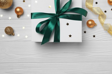 Photo of Flat lay composition with beautiful gift boxes and different Christmas decor on white wooden table. Space for text