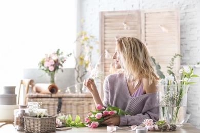 Female decorator creating beautiful bouquet at table
