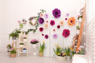 Easter photo zone with plants and paper flowers indoors