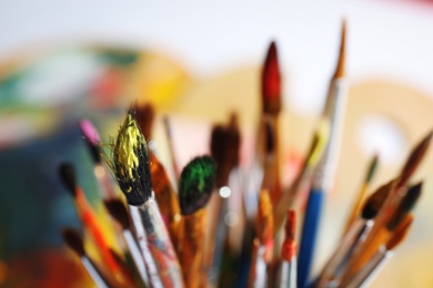 Different paint brushes on blurred background, closeup