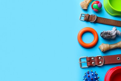 Flat lay composition with dog collars and different accessories on light blue background, space for text