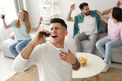 Man singing karaoke with friends at home