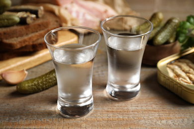 Cold Russian vodka with snacks on wooden table, closeup