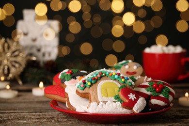 Sweet Christmas cookies on wooden table against blurred festive lights. Space for text