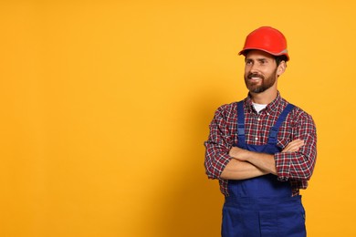 Professional builder in uniform on yellow background, space for text